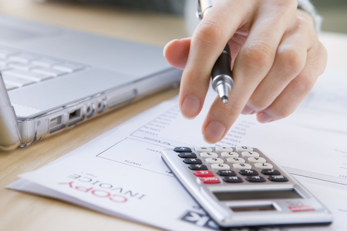 The picture shows a woman reviewing her upcoming bills.