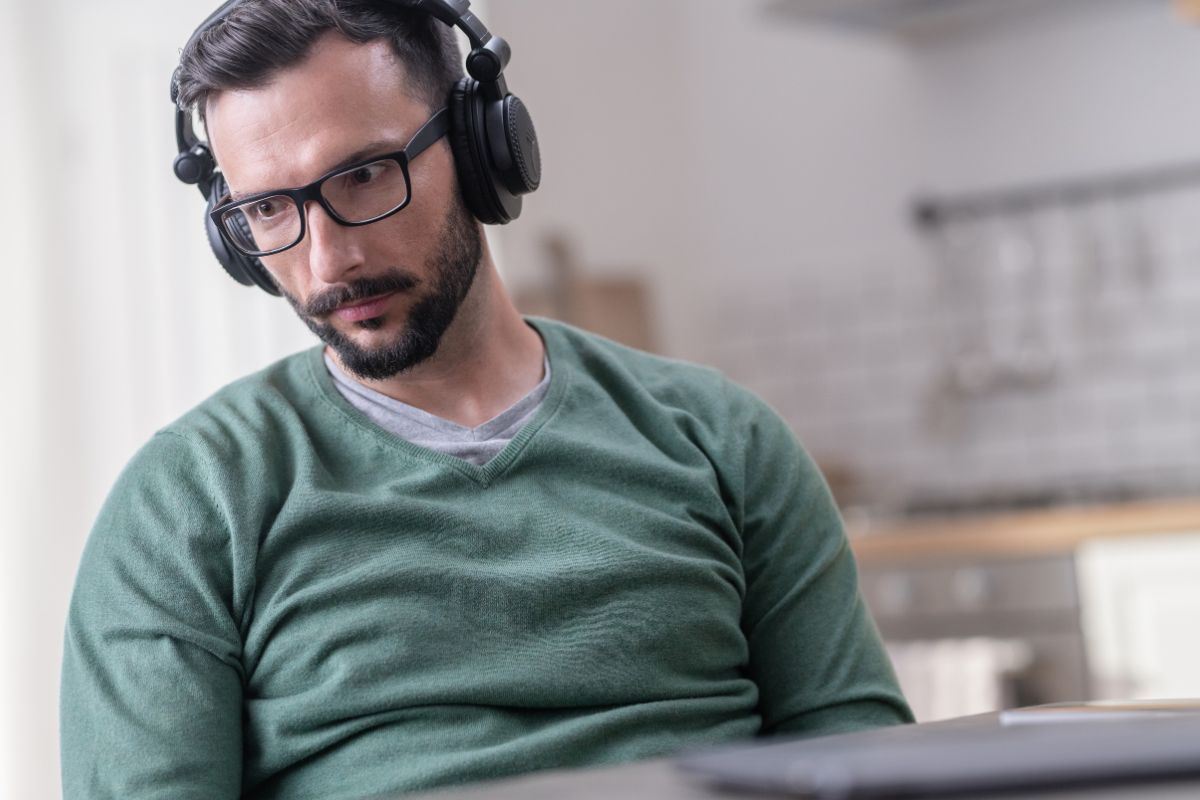 The photo shows a man wearing a headset which means listening to a finance podcast helps you avoid costly mistakes and take advantage of good opportunities. 