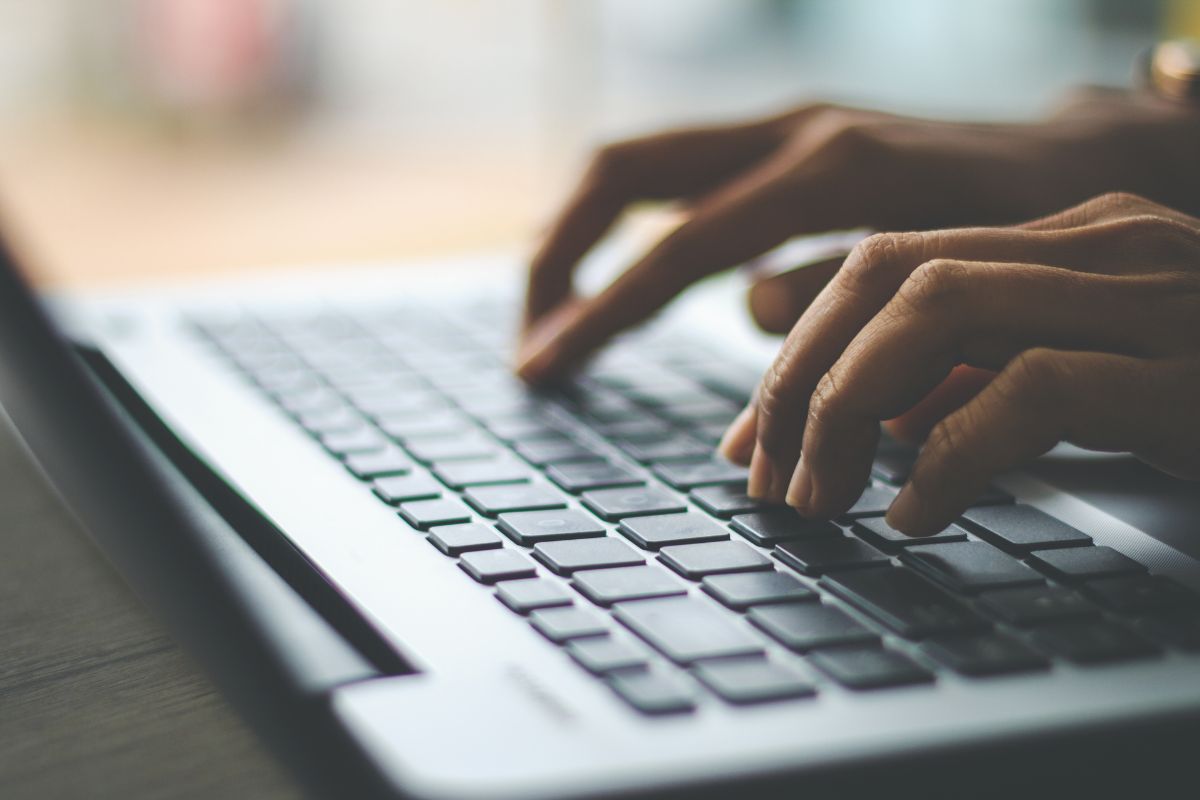 Image of a woman's hand using a laptop.