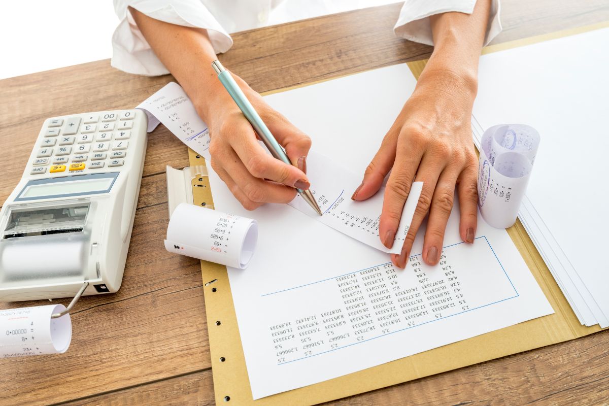A woman's hand tracking her spending.