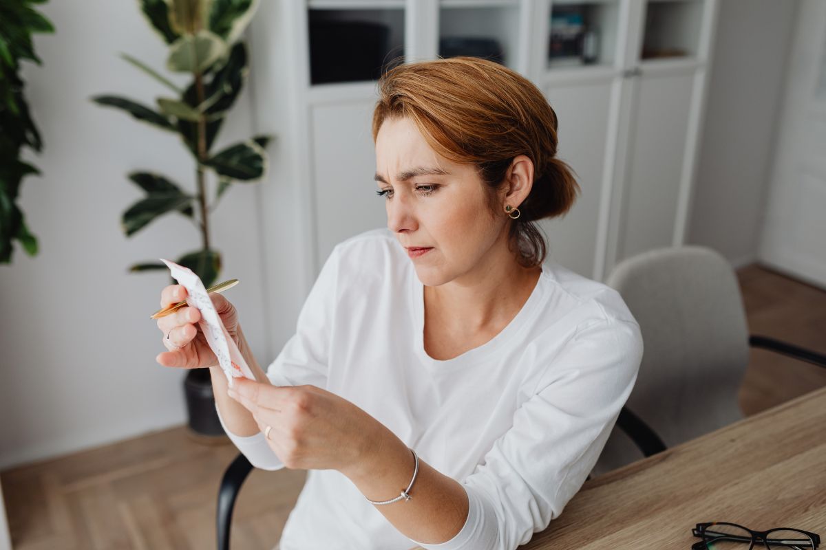The image tells about a girl looking at the receipt which refers to how reflecting on yesterday's spending habits leads to smarter money decisions.