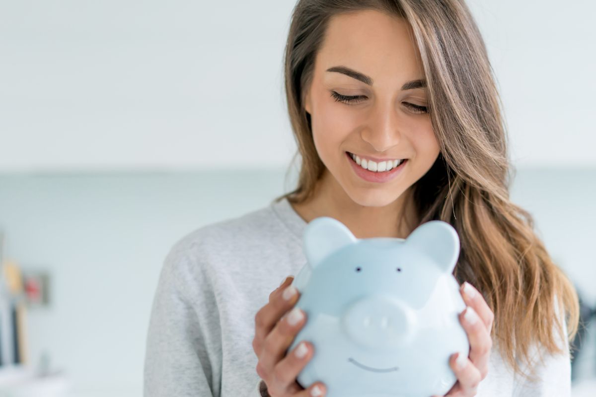 The photo of a woman holding a piggy bank.