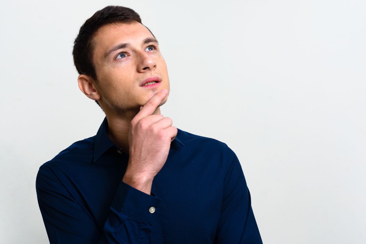 The image shows a man holding his chin while looking at the top referring to thinking like an investor means looking for opportunities, not just purchases.