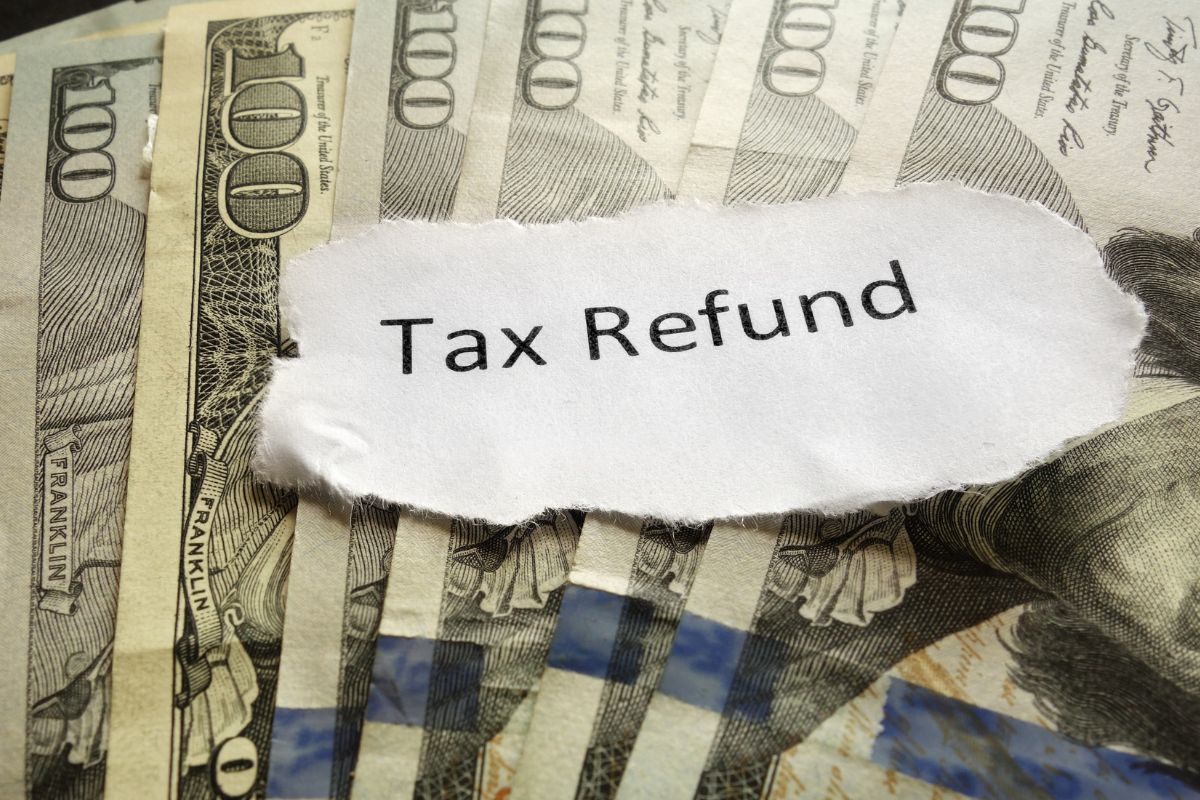 The picture of money and a paper with tax refund wording.