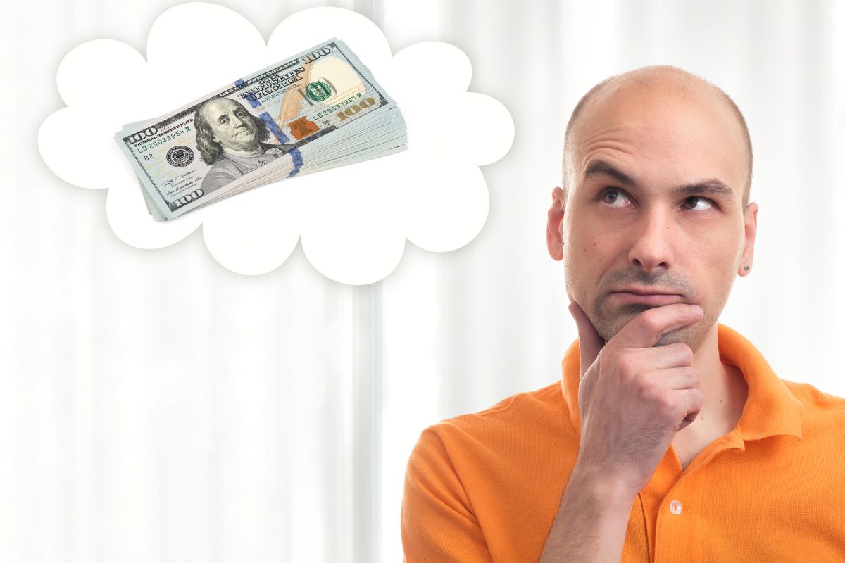 The photo tells about a man thinking about the buck of money which means to visualize financial success can keep you on track even when financial progress feels slow.