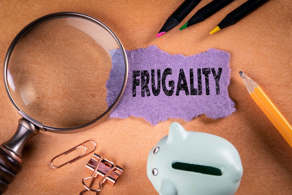 The photo shows a piggy bank and paper with frugality wording.
