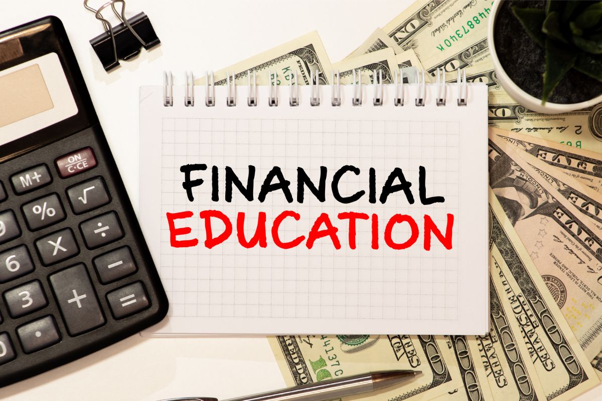 A notebook with financial education wording and money.