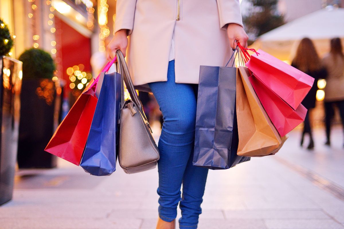 The image shows a girl carrying shopping bags at the mall indicating to avoid emotional spending, sticking to a plan keeps money in the right place.