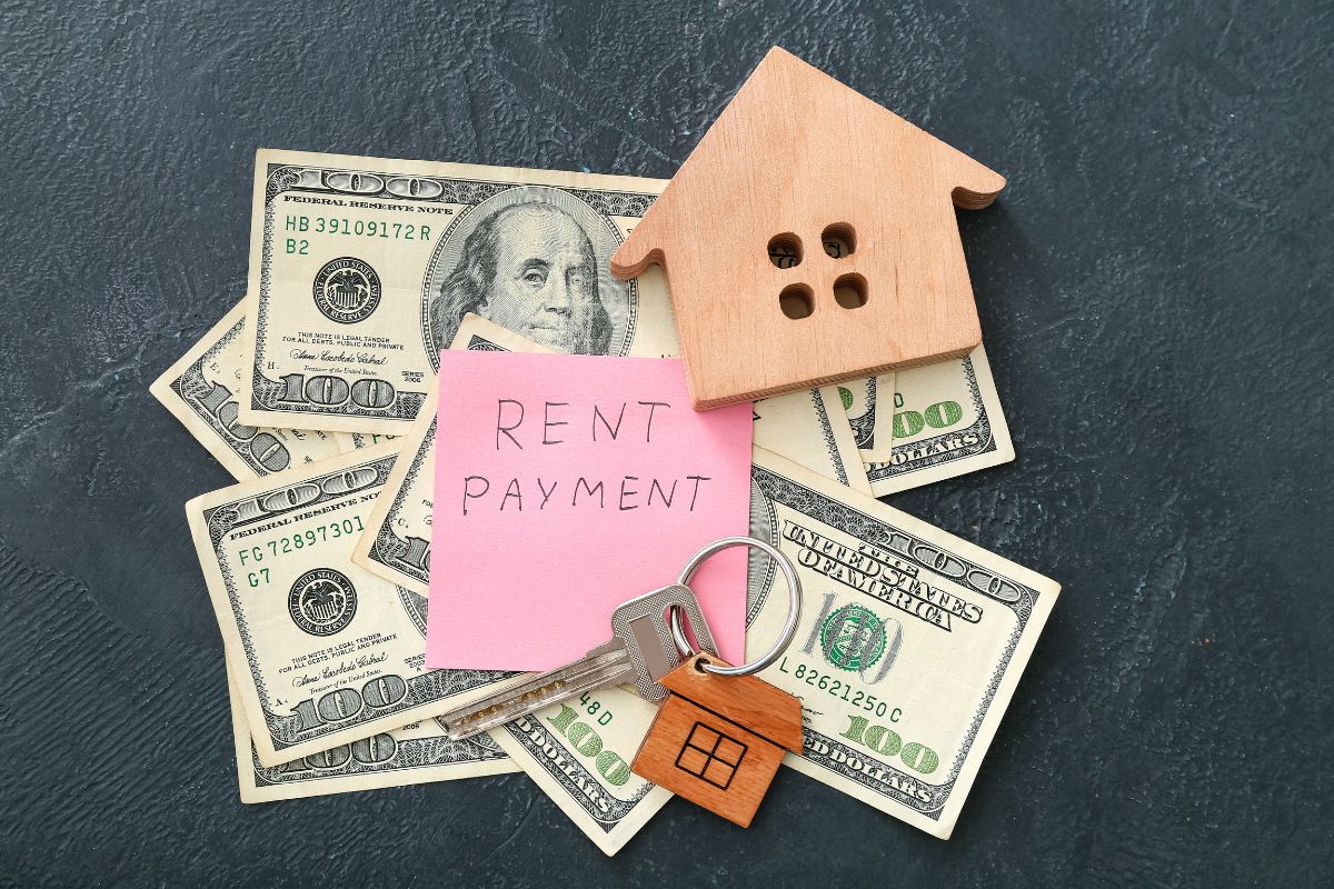 The picture shows dollar bills, a key, a mini house, and a piece of paper with notes referring to defined fixed expenses that help you pay for the rest of your spending.