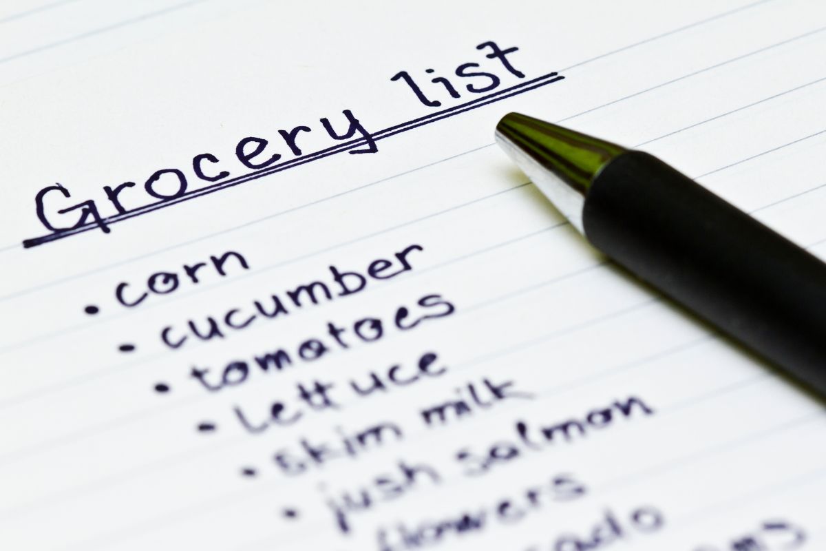 The photo shows a pen and paper with a grocery list.
