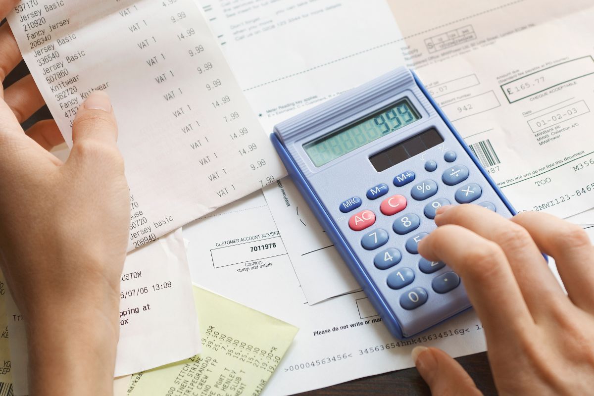 The photo shows a woman calculating expenses.