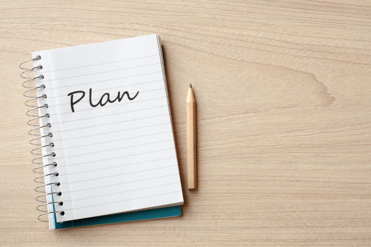 Image of a pen and a notebook with plan wording.