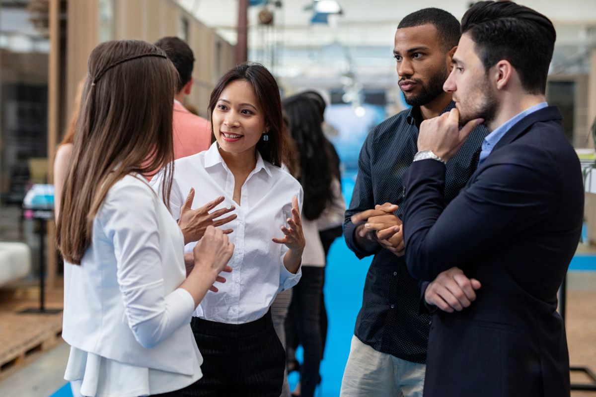 The image shows a group of people talking together which means to plan productive income to make progress toward bigger financial goals.