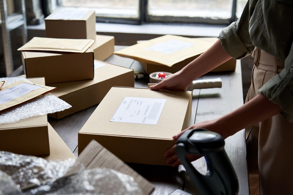The picture shows boxes and a girl organizing them indicating that starting a Dropshipping business is a great way to build passive income without upfront costs.