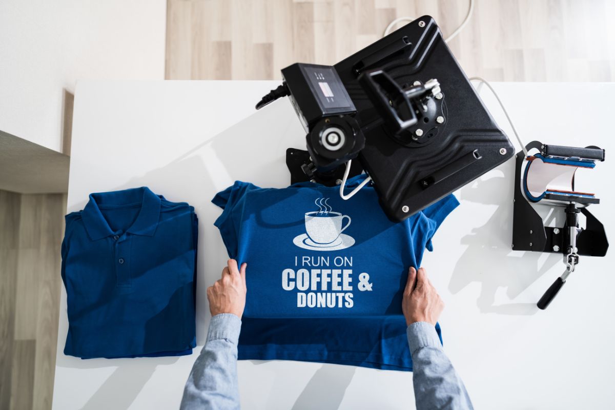 The photo shows a machine with a shirt which refers to the launch of a print-on-demand store is an easy way to earn online with little investment.
