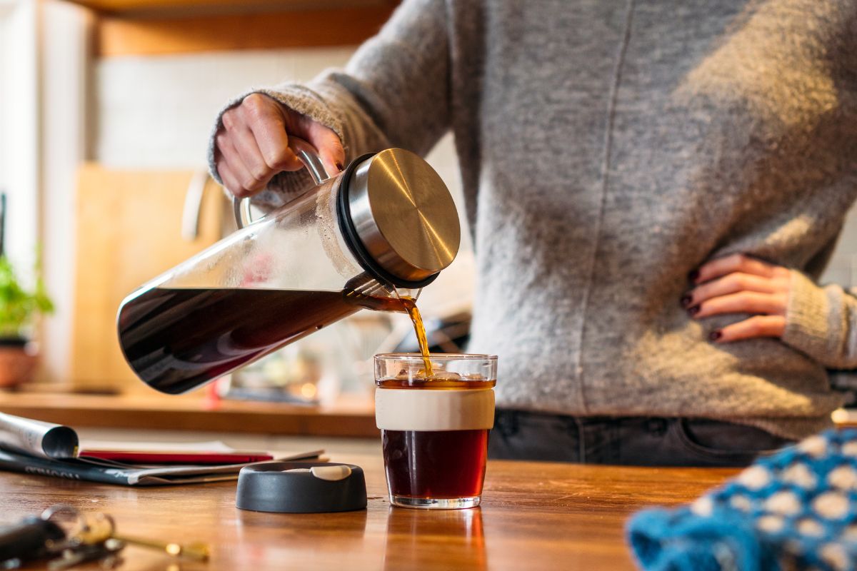 The photo tells about a girl pouring a cup of coffee which refers to brewing coffee at home instead of buying daily to save a lot of money over time.