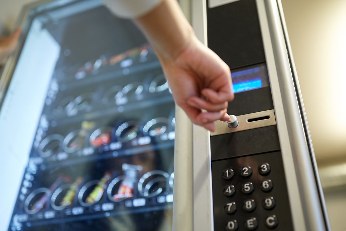 Photo of a woman's hand renting out a vending machine.