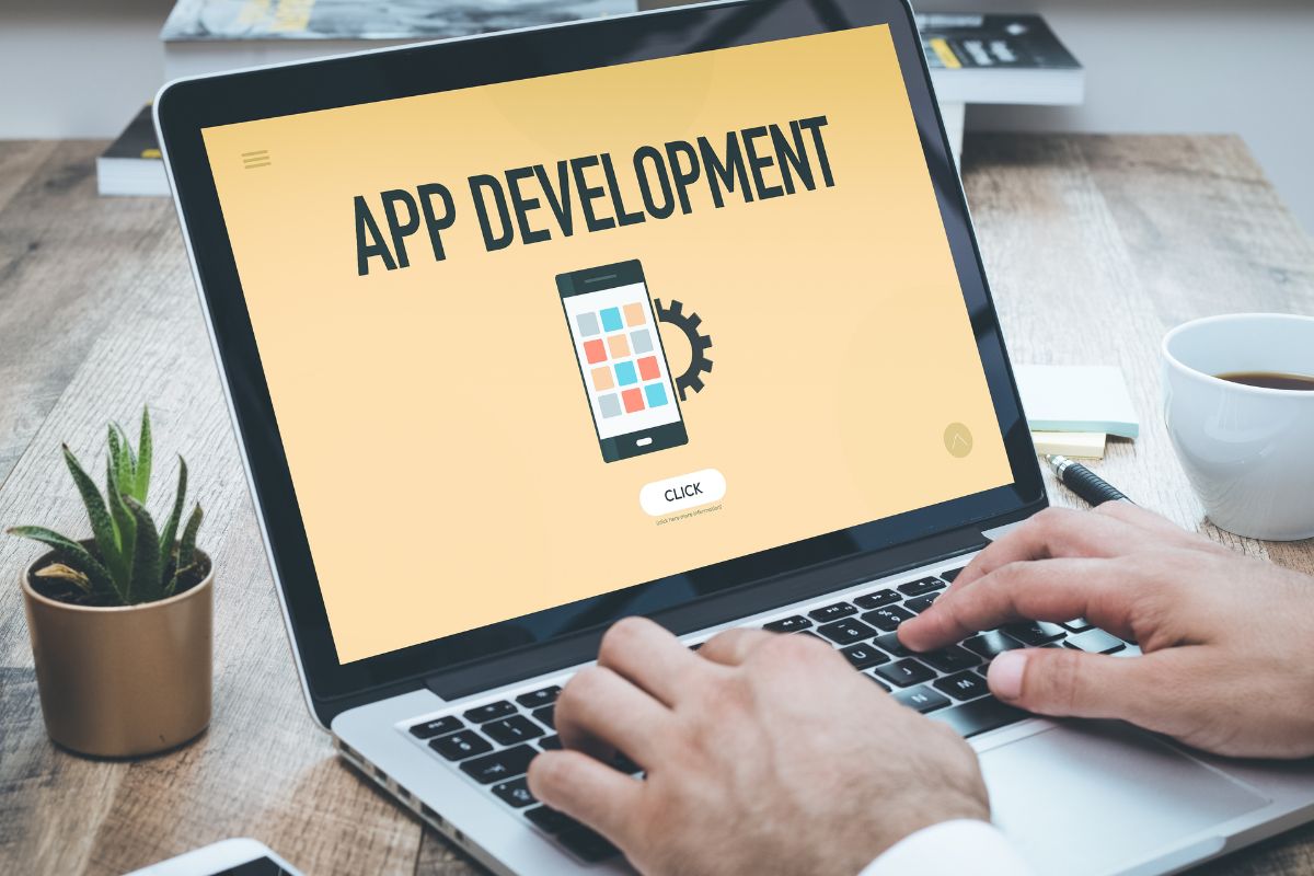 The picture of a man's hand working on app development.