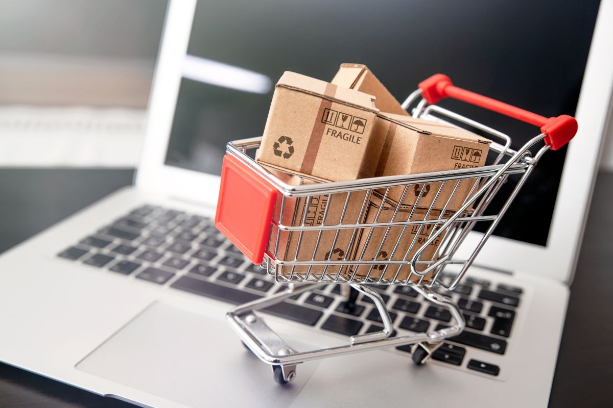 An image of a laptop and a cart with boxes.