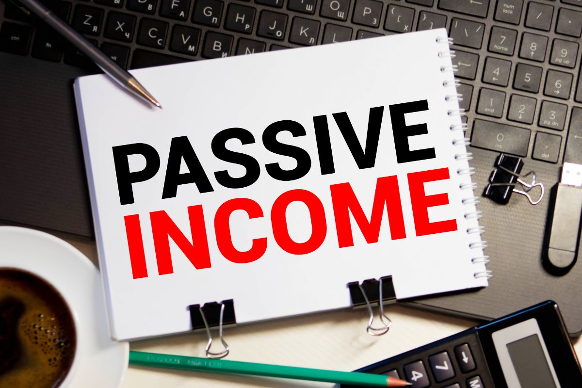 Picture of a laptop and a notebook with passive income wording.