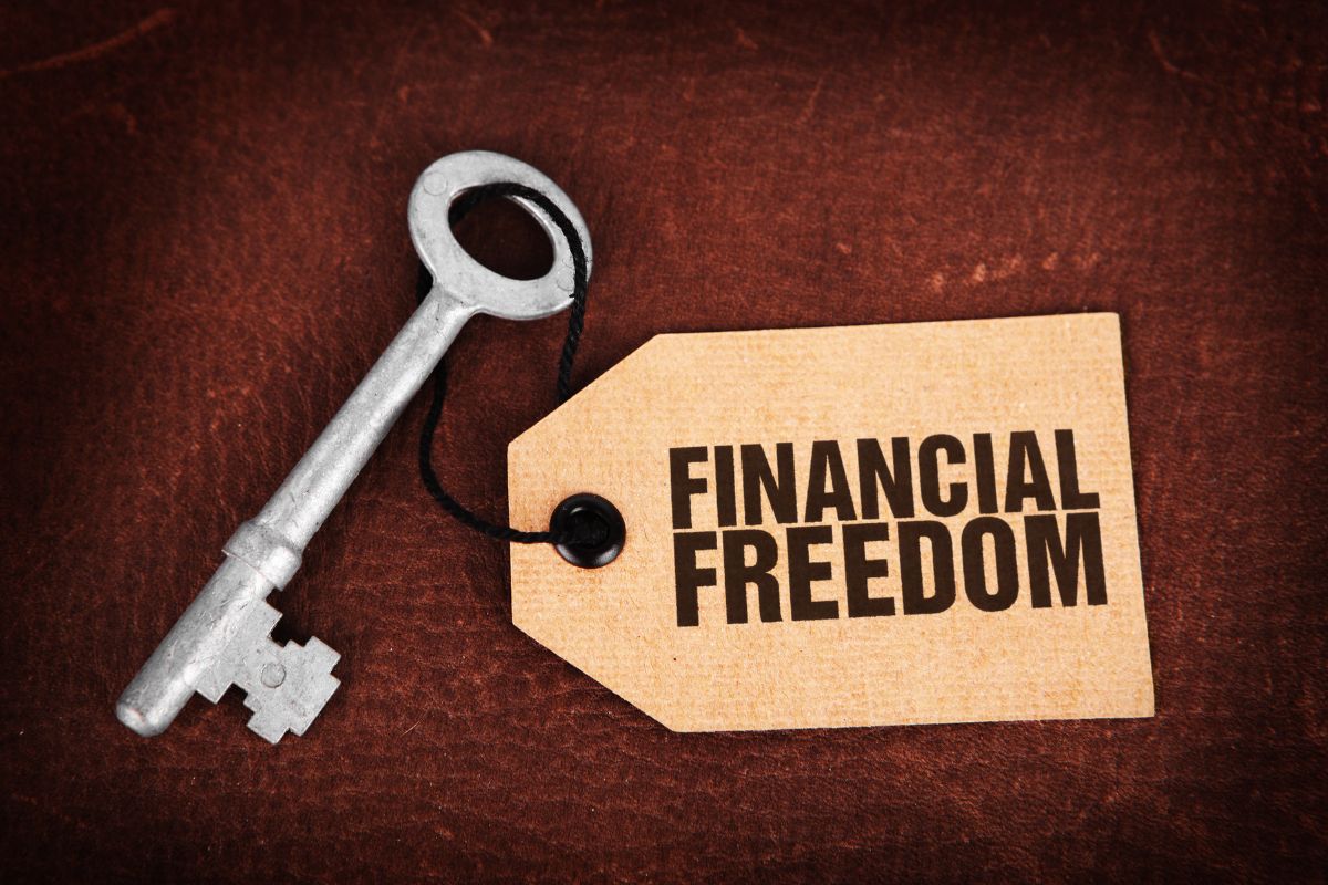 The photo tells about a key and a tag with notes referring to why financial freedom matters means having enough income to cover expenses without relying on a traditional job.