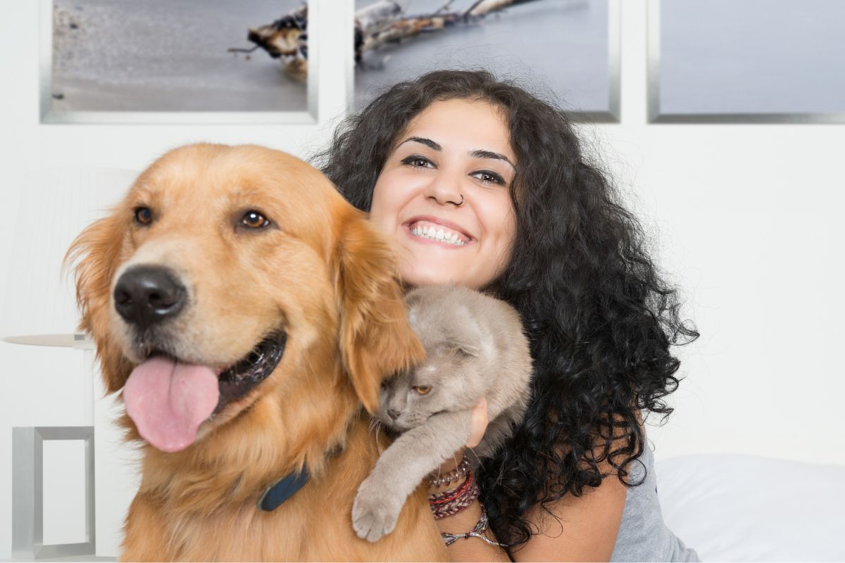 The image shows a girl taking care of a cat and dog indicating that pet sitting with Rover makes it easy to find pet owners who need reliable help.