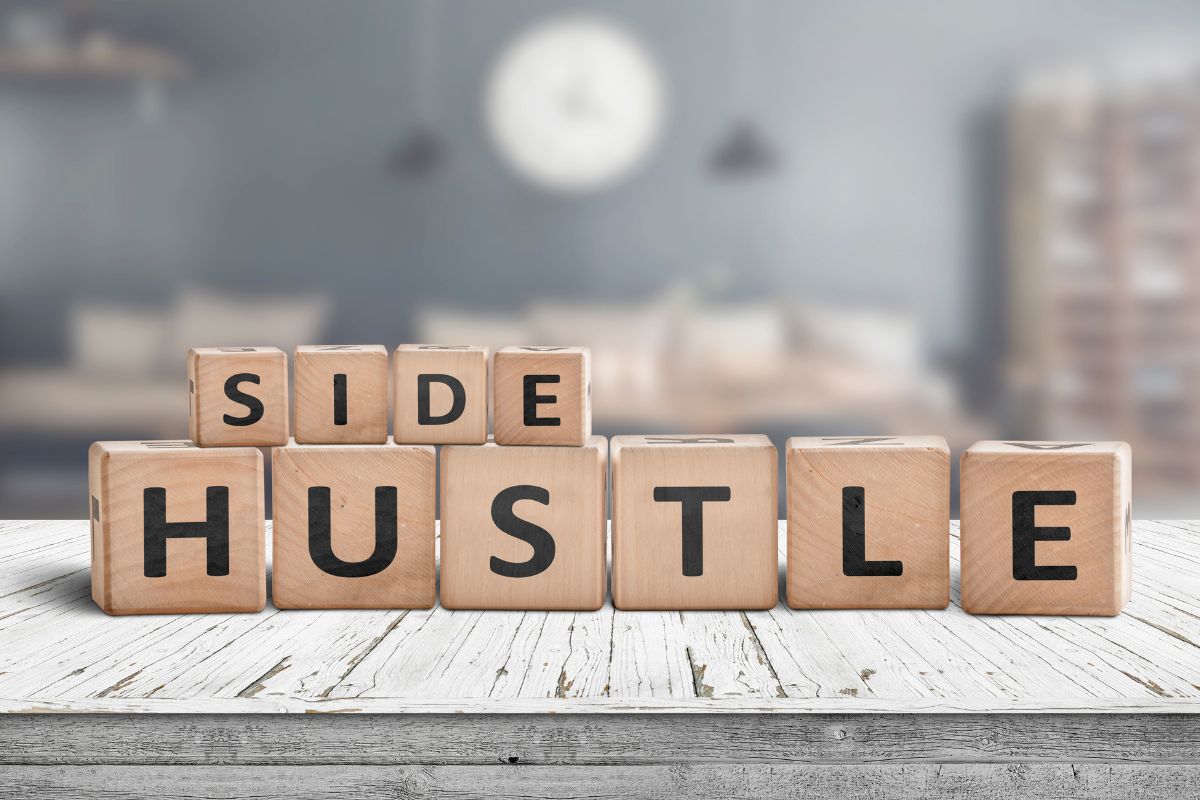 The picture shows wooden cubes with letters which refers to finding the perfect side hustle for you to earn passive income while at home and build financial independence.