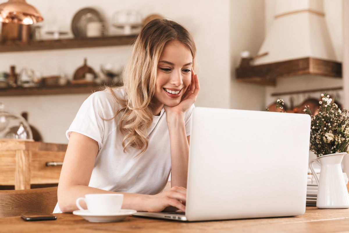 The image shows a coffee, a plant, a phone, and a girl using a laptop which means selling digital products is a great way to make money online without worrying about inventory. 