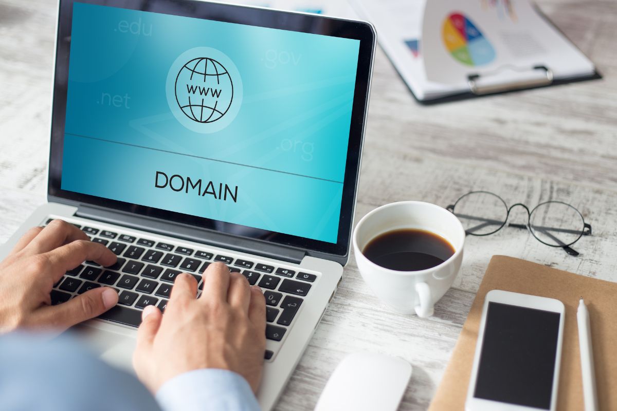 The photo shows a man's hand flipping domain names online.