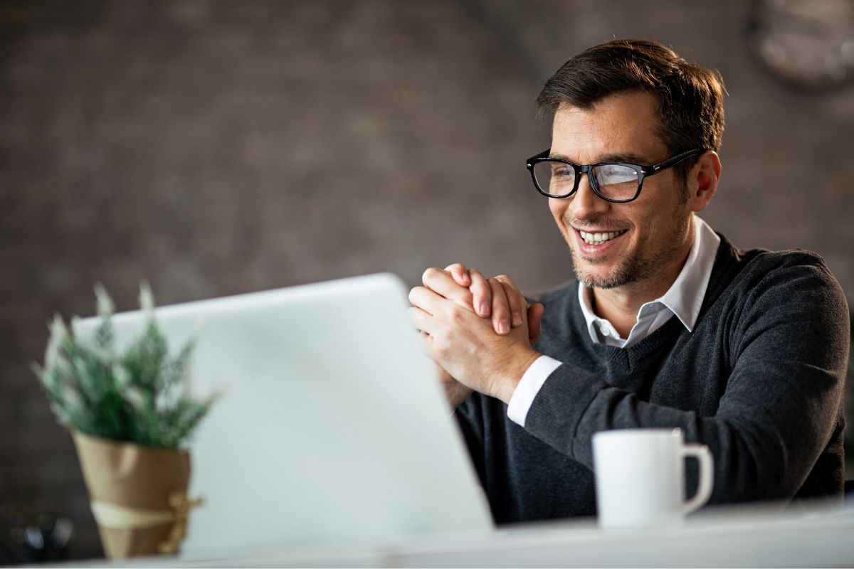 The photo of a plant, a mug, and a man looking at the laptop referring to renting out digital billboards can earn passive income and increase prices as traffic grows.