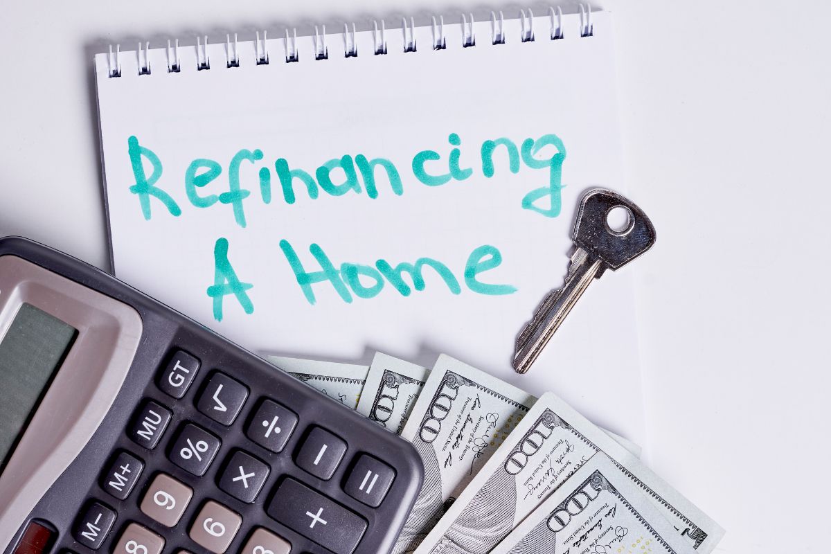The photo tells about a key, dollar bills, a calculator, and a notebook with notes indicating if refinancing lowers monthly payments or shortens loan terms helps you guide what type of refinance makes sense.