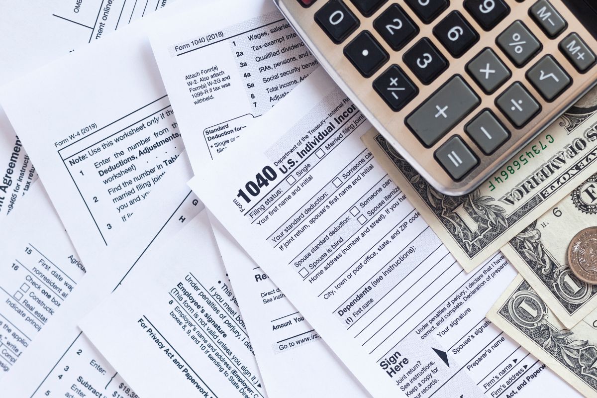 The picture shows money and tax forms.