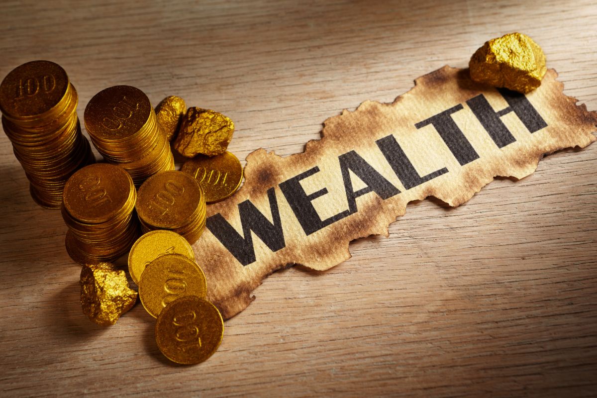 The photo tells about golden coins and a piece of paper with a note that refers to beliefs about money and wealth that can help you build better habits.