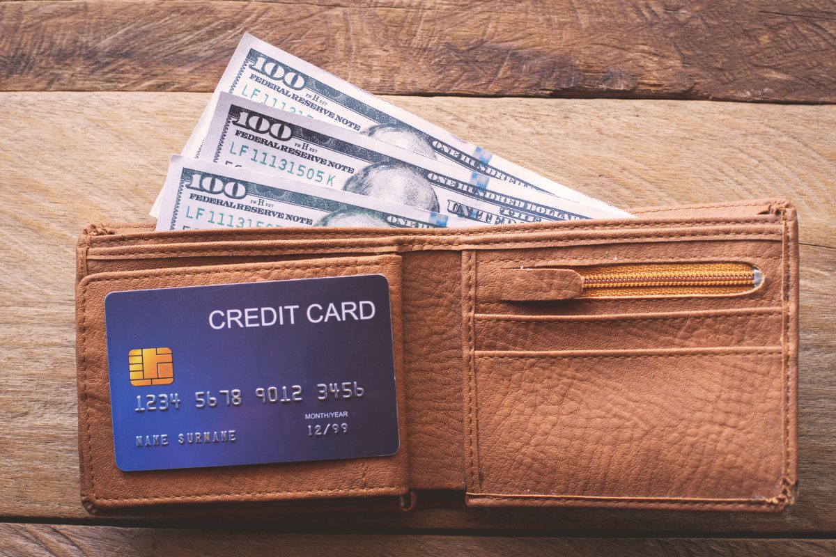 A picture of a wallet with a credit card and money.