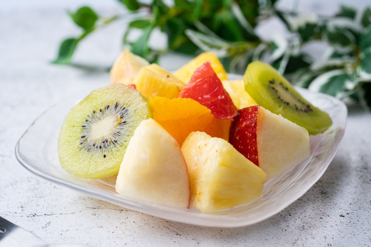The picture tells about a plant and a container with different kinds of fruits which means pre-cut fruits cost way more than buying whole produce, chopping at your home can save a lot of money over time.