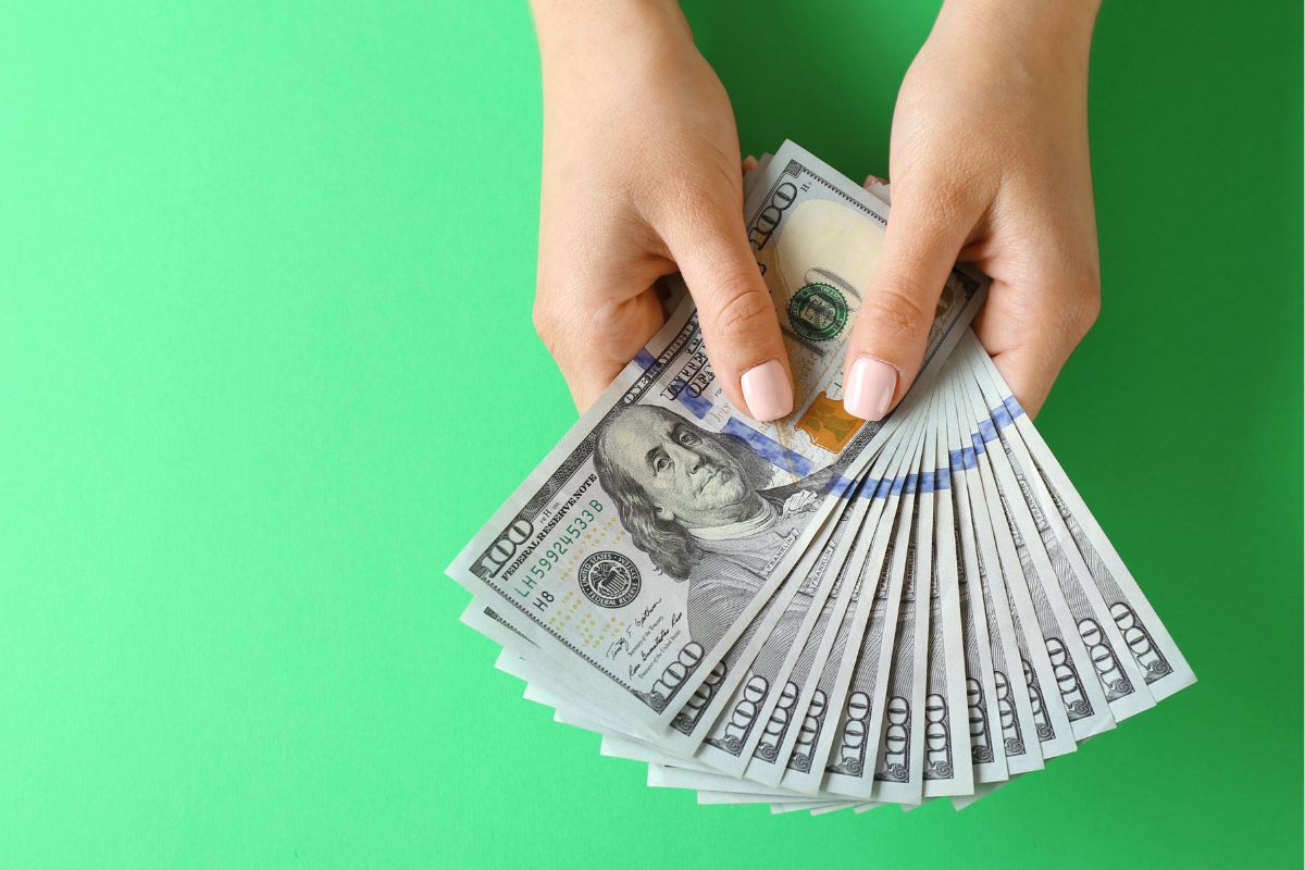 The photo shows a girl's hand holding dollar bills which refers to creates a safety net for pursuing new opportunities and makes it easier to handle life's changes.