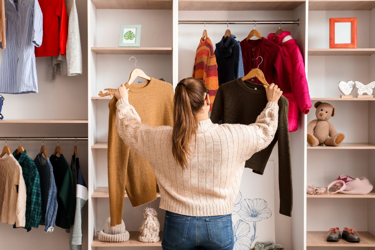 The photo tells about hung clothes, stuffed toys, and a girl choosing between the two clothes which means using what you already have makes a no-buy year much easier.