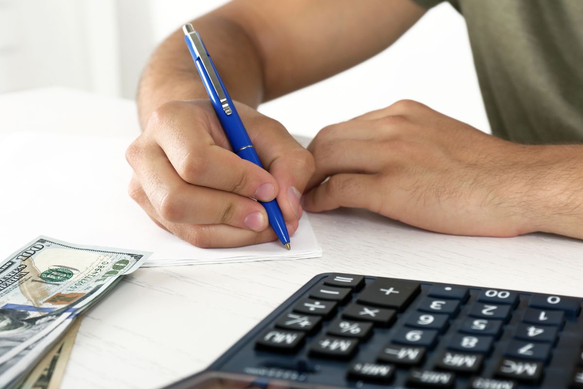 The image of a man's hand sticking to a budget.