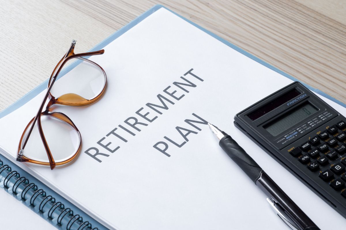 The picture is about a calculator, a pen, eyeglasses, and a notebook with notes which refers to a plan for retirement that ensures you can enjoy financial freedom when you're older.