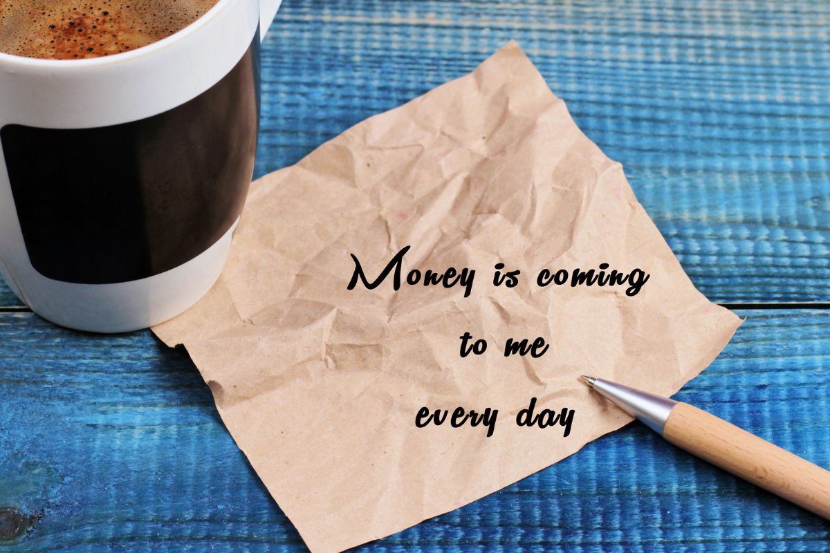 The image tells about a coffee, a pen, and a piece of paper with notes referring to the use of money affirmations to motivate you can help you stay confident bout your financial future.