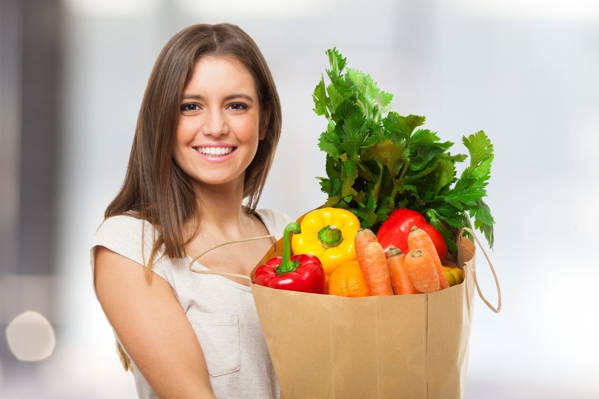Image of a woman with a bag of groceries.