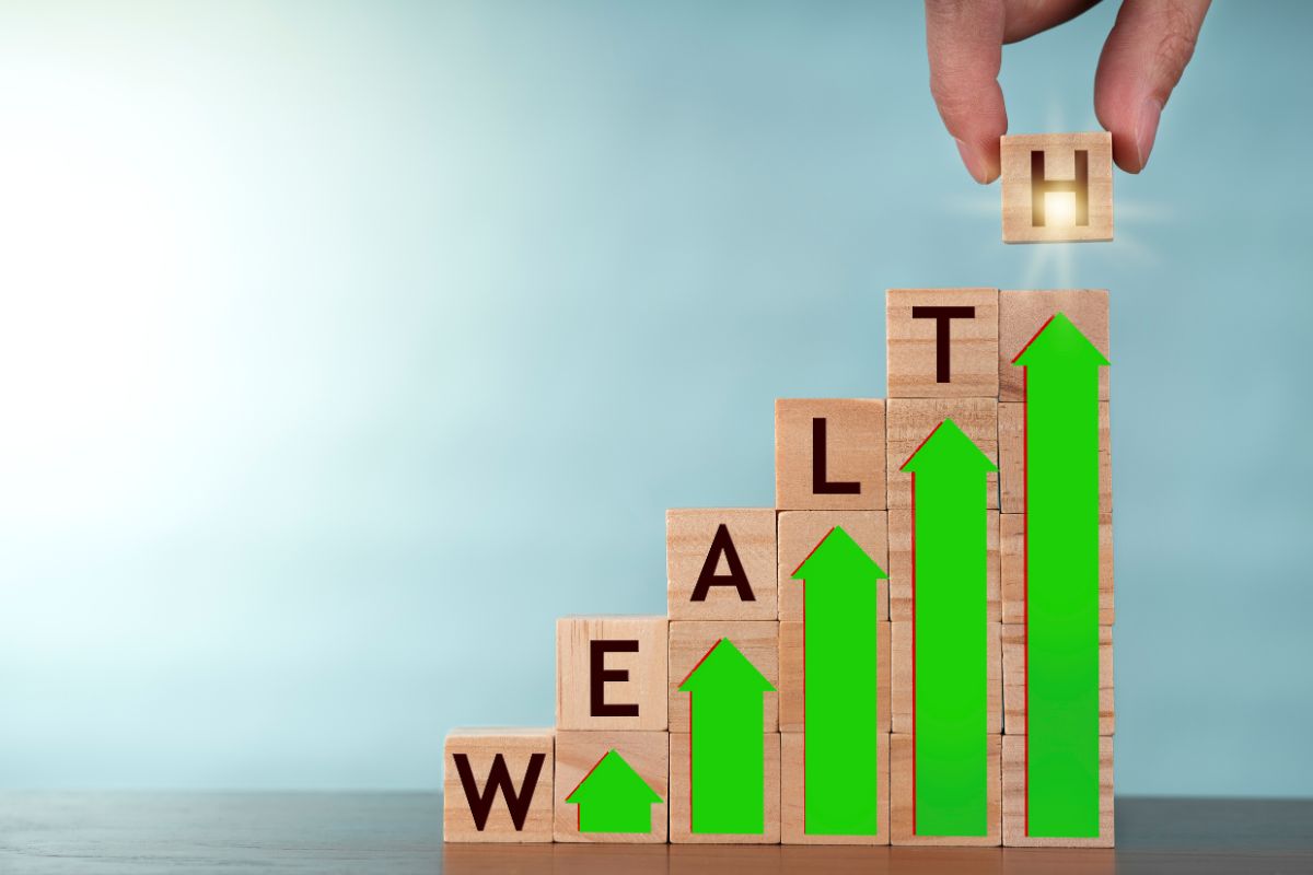 The image shows wooden cubes with letters, arrows, and a man's hand putting the last letter on it which refers to focus on long-term wealth-building strategies that help with smart decisions.