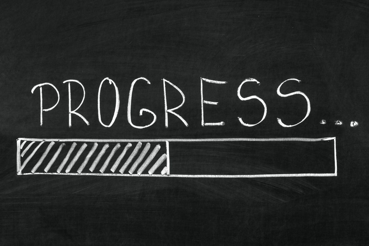 Image of a blackboard with progress wording.