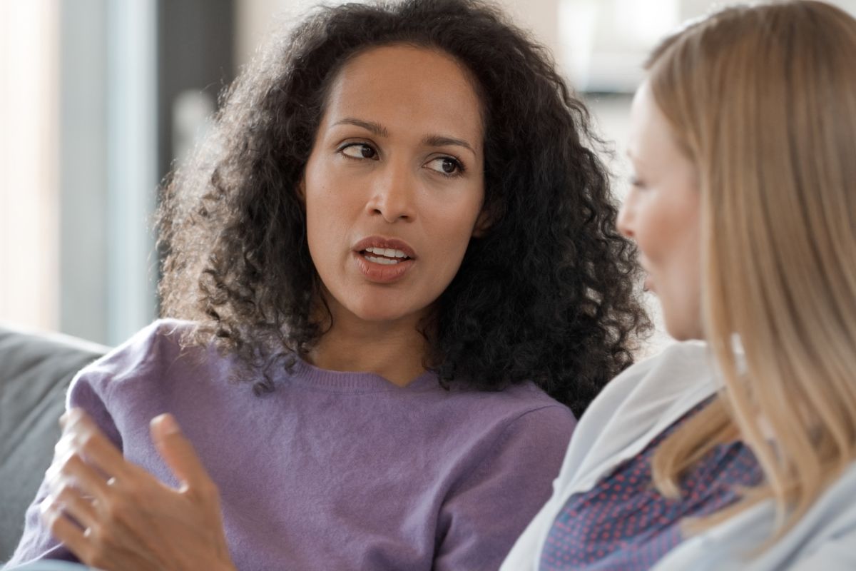 The picture shows two girls talking to each other which means that staying accountable makes you less likely to give in to impulse spending.