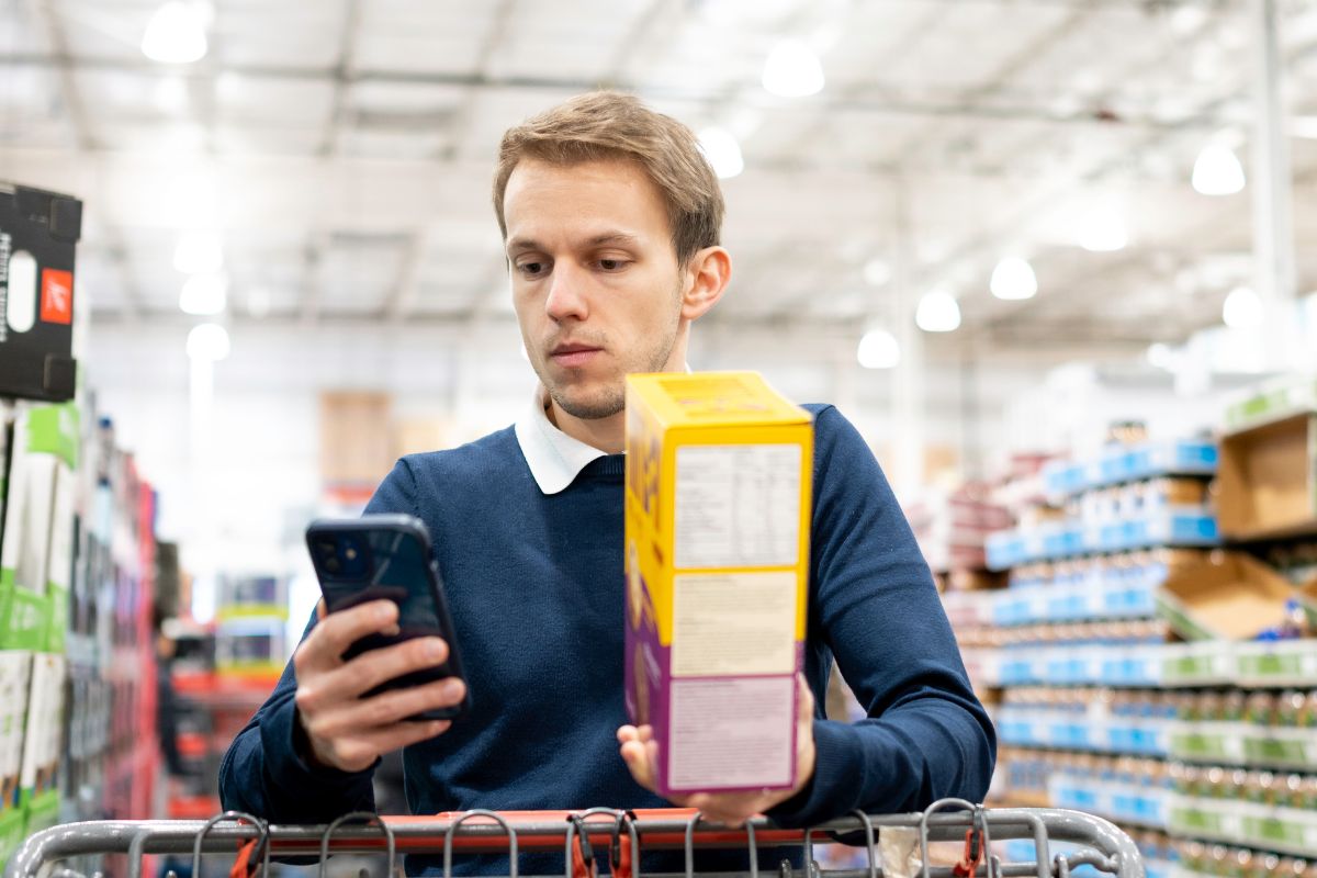 The photo of a man comparing prices.