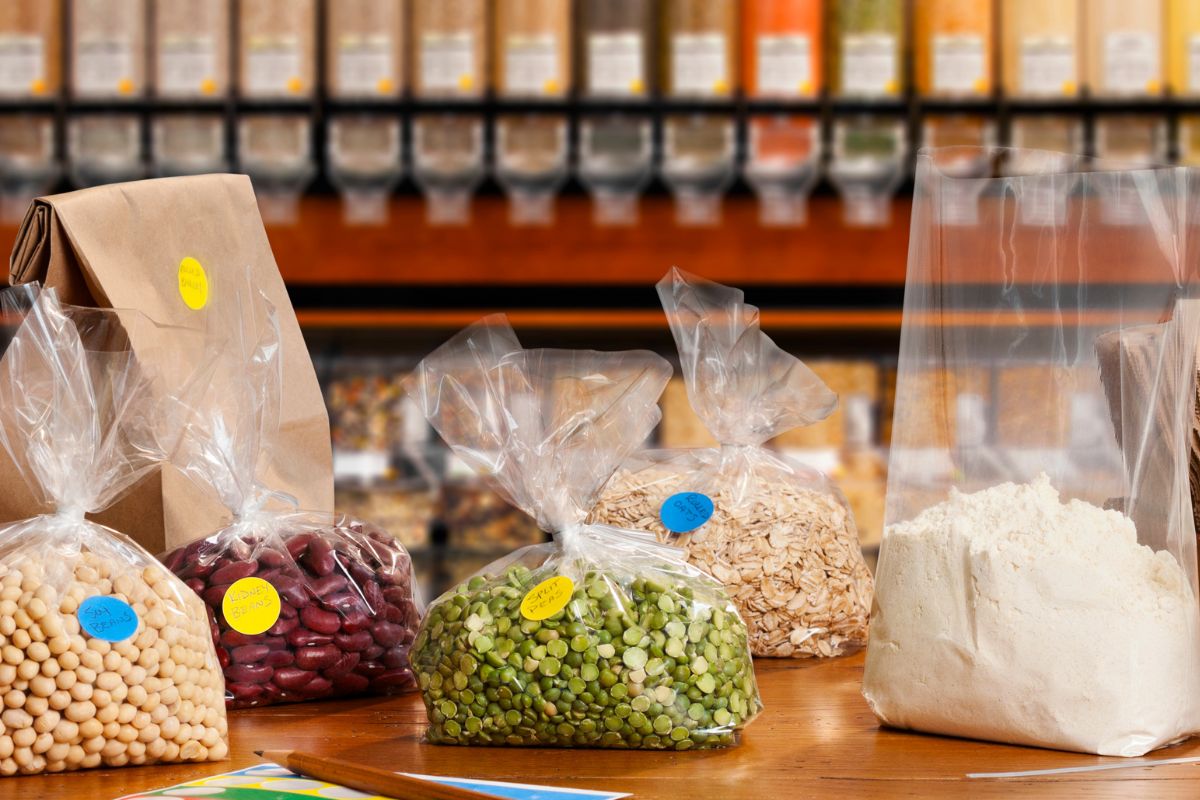 The photo tells about different kinds of spices and plastic containers with other varieties of beans and flour indicating that buying in bulk for staple items helps you avoid spending last-minute grocery tips.