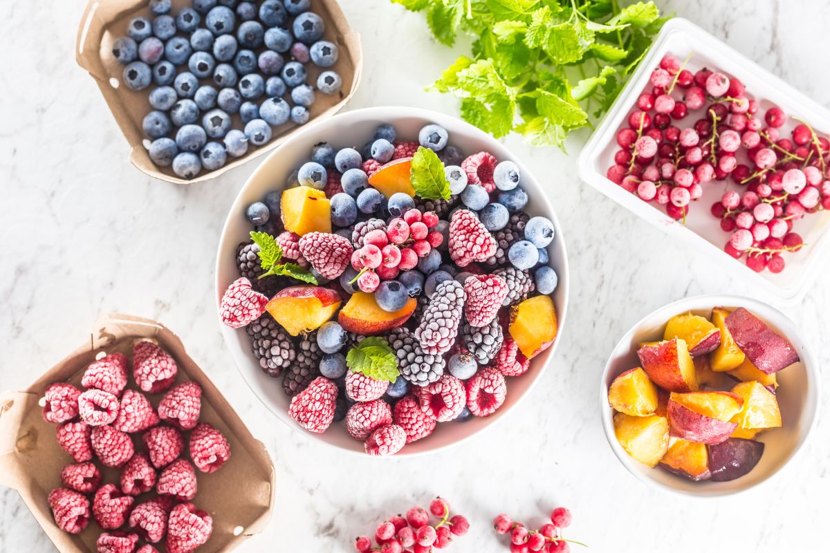 The photo tells about the bowls with frozen fruits on the table which refers to choosing frozen fruits makes it easier to eat well without overspending.
