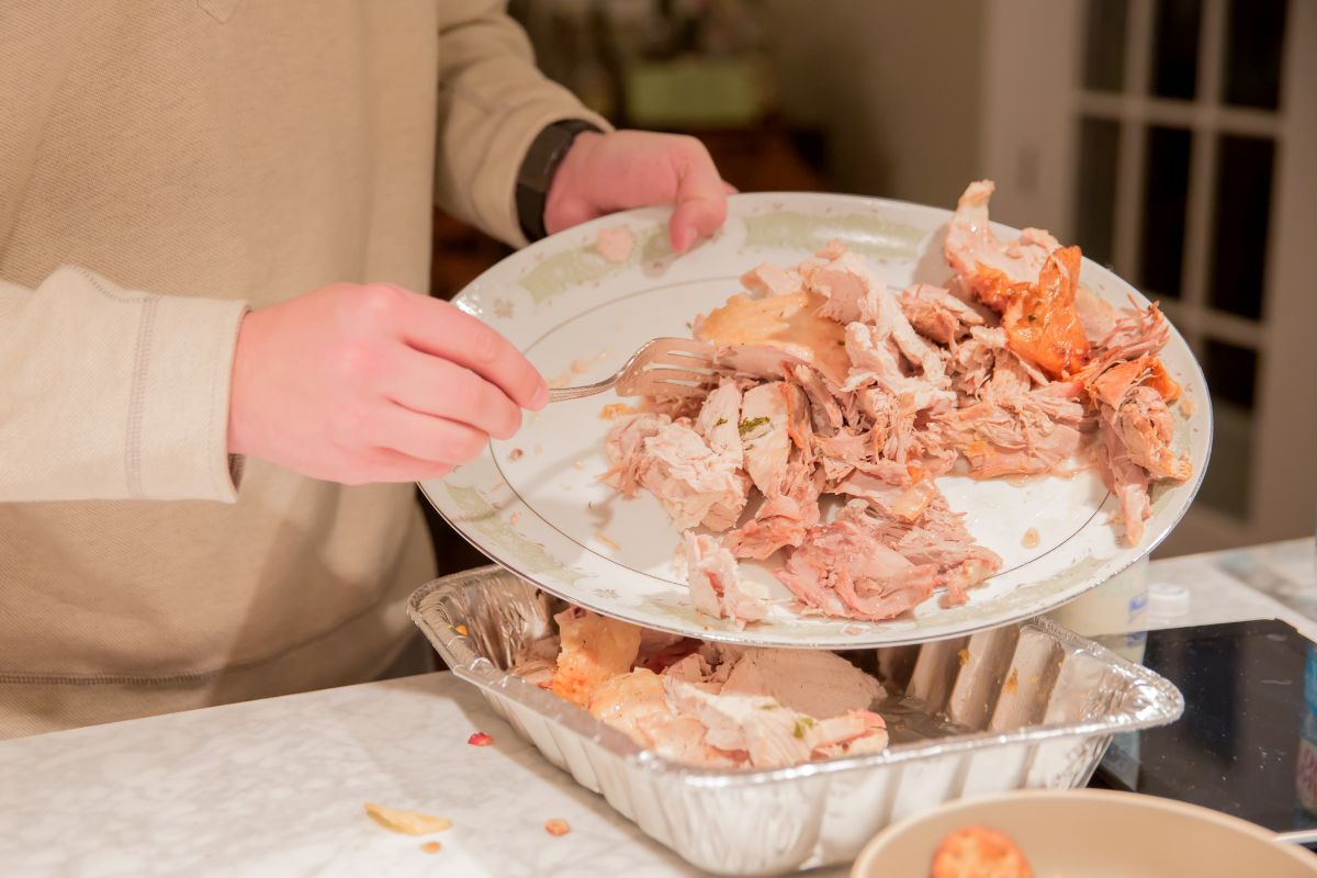The picture of a man's hand utilizing leftovers.