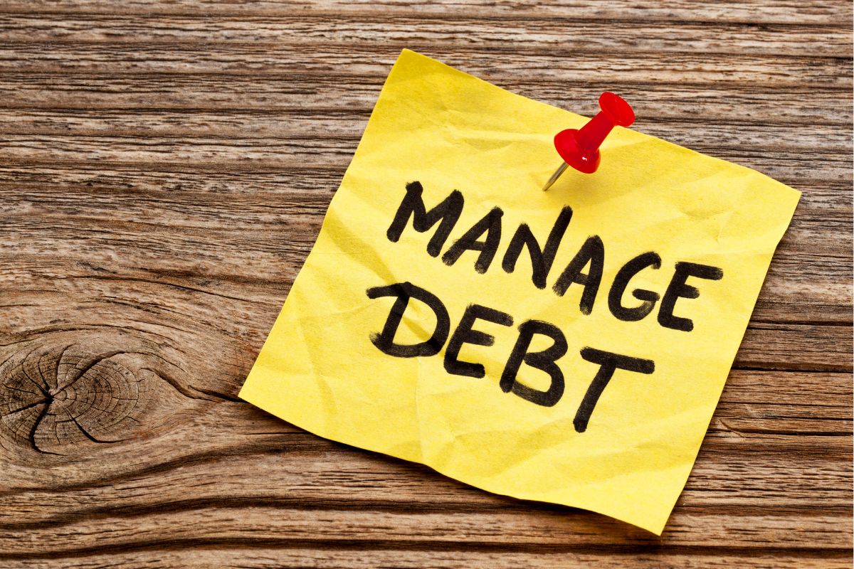 The photo tells about a piece of paper with notes pinned on the wood which means limiting debt and managing loans wisely frees up money for better opportunities.