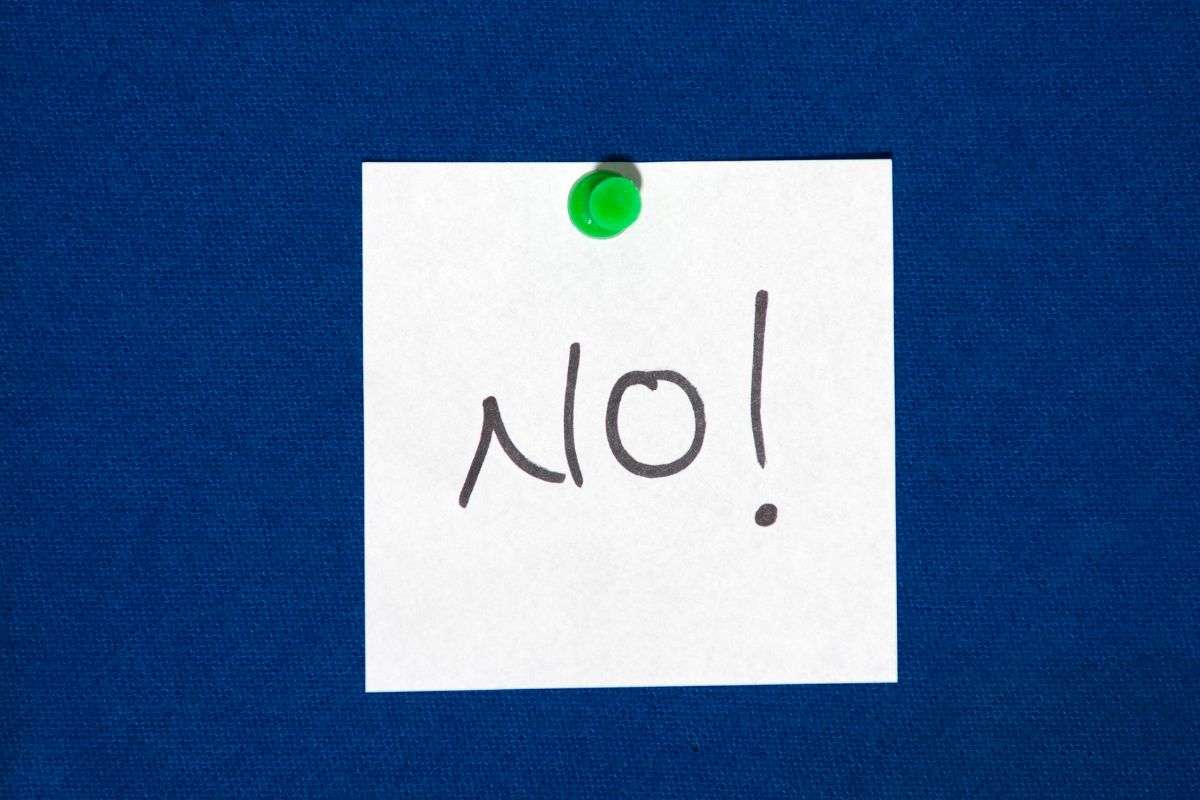 The image shows a piece of paper with a note pinned on the wall referring to no, you shouldn't feel guilty and there were many ways for your children to get through school.